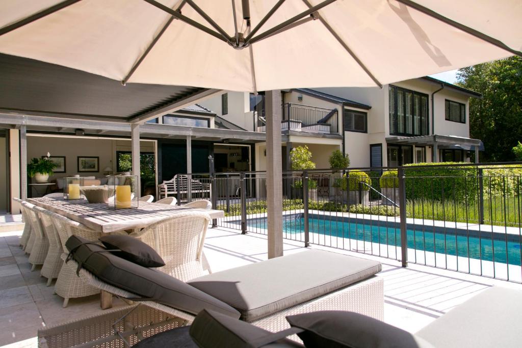 陶波柏银特别墅酒店的庭院配有桌椅和遮阳伞。