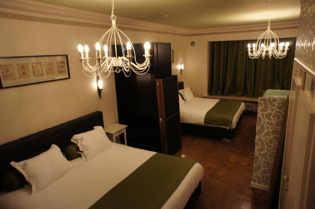 布鲁塞尔J和R布鲁塞尔市公寓的酒店客房设有两张床和吊灯。