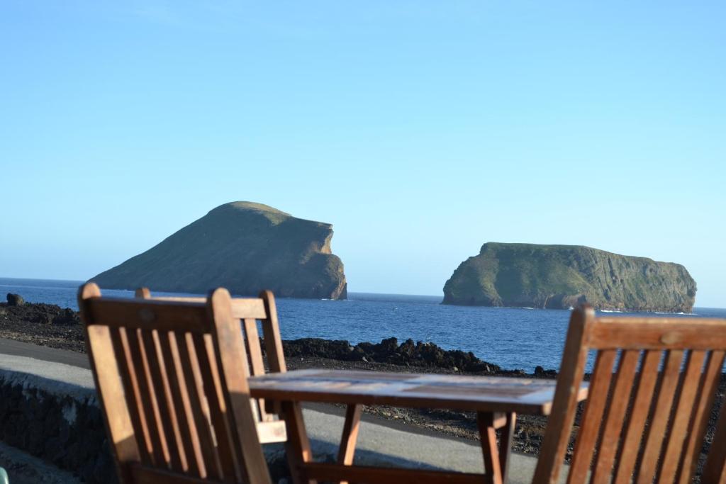 FeteiraCasa Doce Mar的两把椅子坐在海边