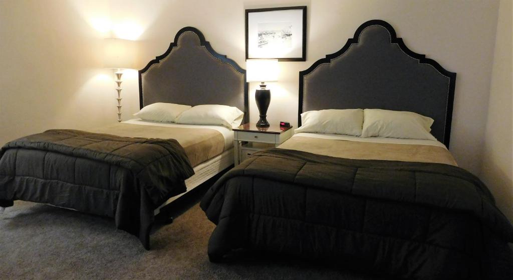 瓦拉瓦拉Capri Motel的酒店客房设有两张床和一张带台灯的桌子。