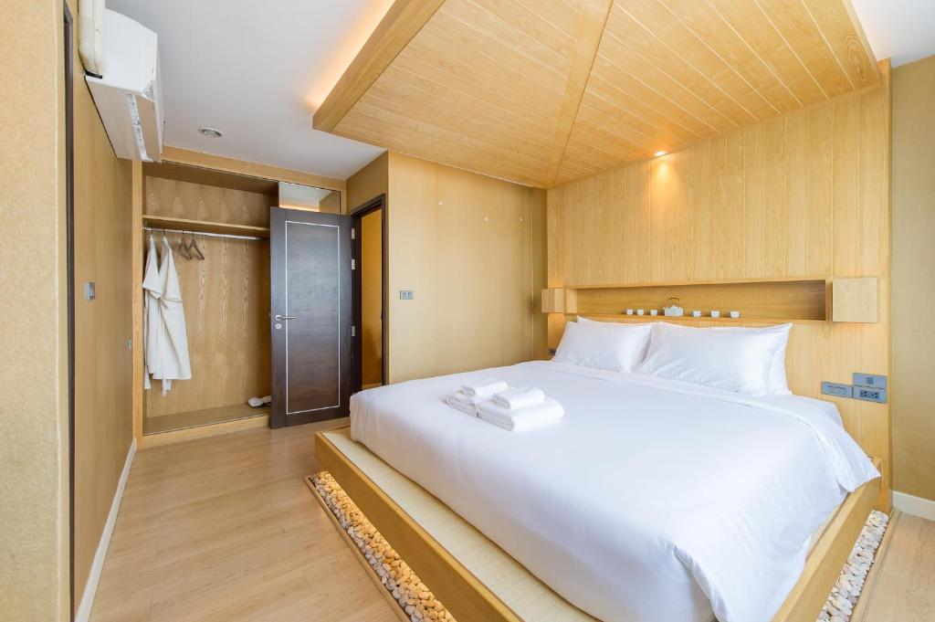 曼谷泽尼克酒店的卧室配有一张白色大床和一个衣柜