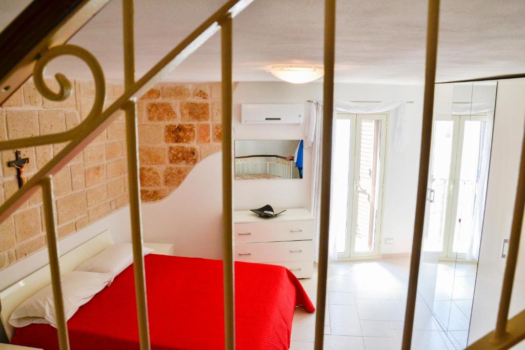 莫诺波利Dimora Arco Antico的一间卧室配有红色的床和镜子