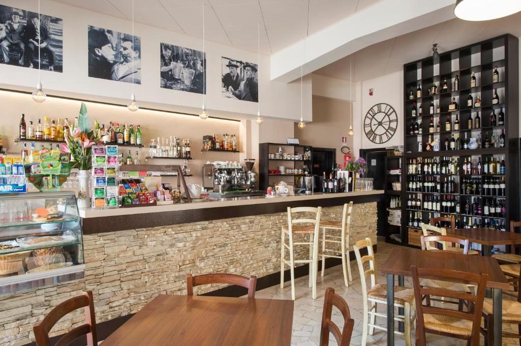 贝尔蒂诺罗Albergo Colonna的餐厅内的酒吧配有木桌和椅子