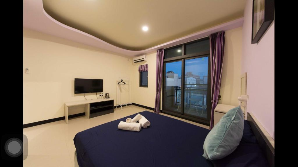 恒春古城垦丁橘色旅店的一间卧室配有一张床,上面有两条毛巾