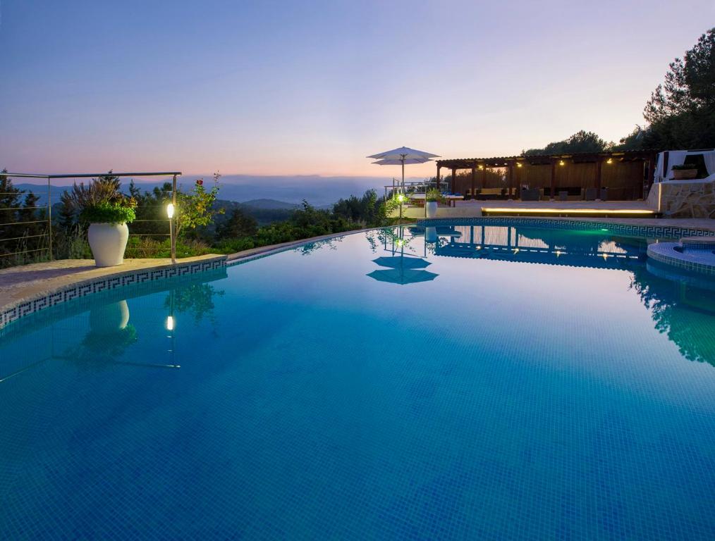 圣塔格鲁迪斯Villa Buscastells的一座蓝色的大型游泳池,背面是日落