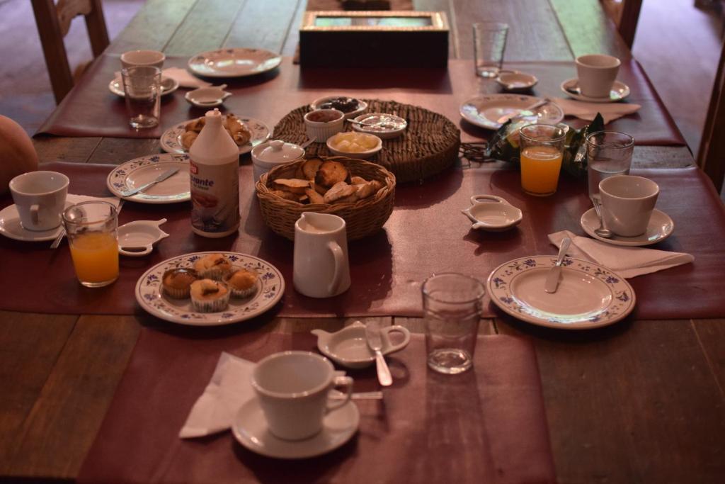 Villa DoloresPosada Niña Juana的餐桌,带食物盘和橙汁杯