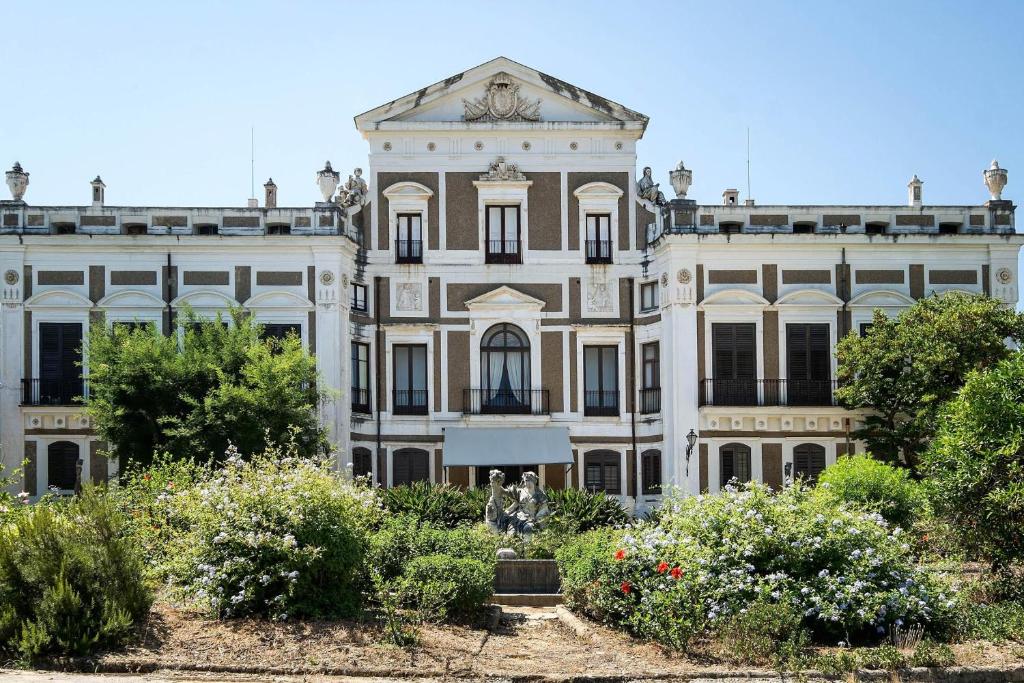 巴格里亚Vero Sicily - Sicilian Garden Cottages的一座大建筑,上面有一个钟