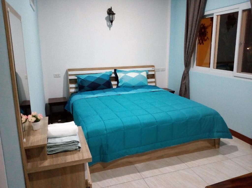 大城班潘妮旅馆的一间卧室配有一张带蓝色棉被的床