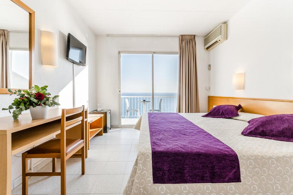 滨海圣波尔格兰索尔酒店的配有一张床和一张书桌的酒店客房