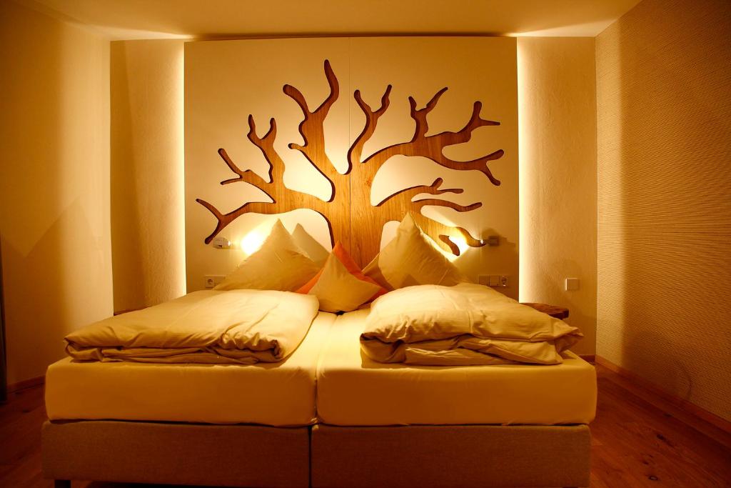 贝斯特维希奈德尔弗莱尔酒店的卧室配有一张床铺,墙上挂着一棵树