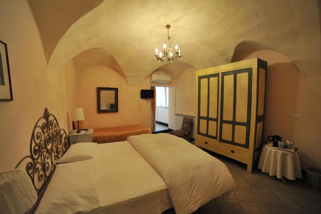 菲纳莱利古雷艾拉斯莫客房和早餐旅馆的一间卧室配有一张大床和一个吊灯。