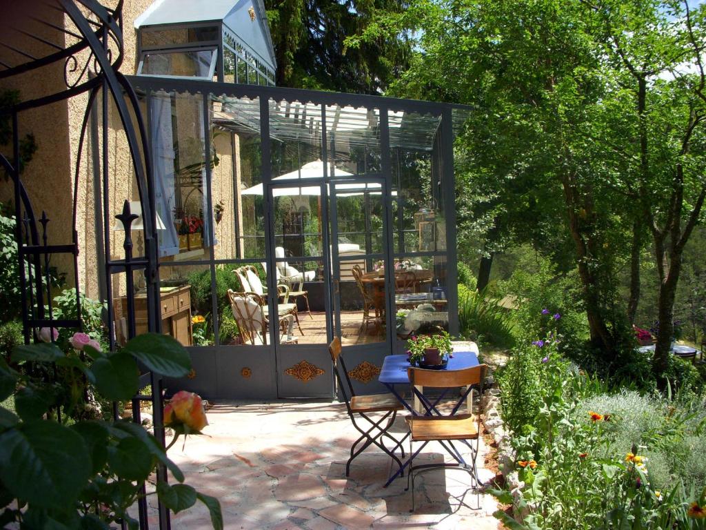 Thorenc拉贝卡西亚酒店的一个带桌子和玻璃房子的花园