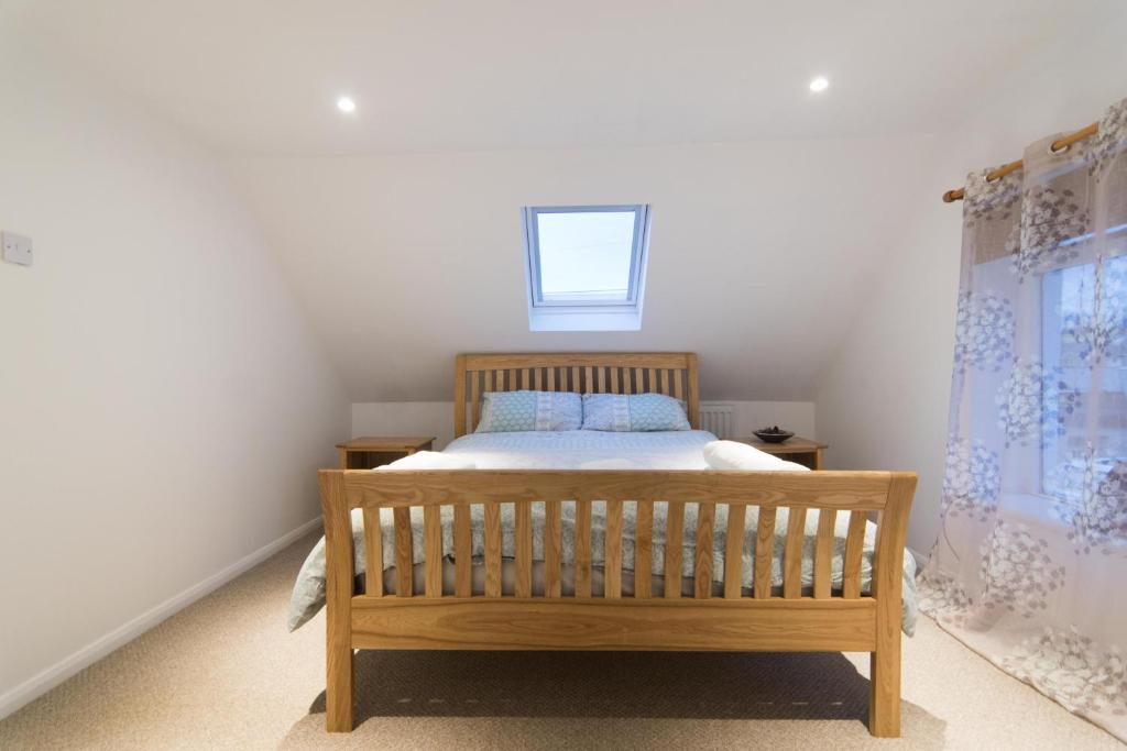 DouneBlair Drummond Holiday Home的一间卧室设有一张木床和一个窗户。