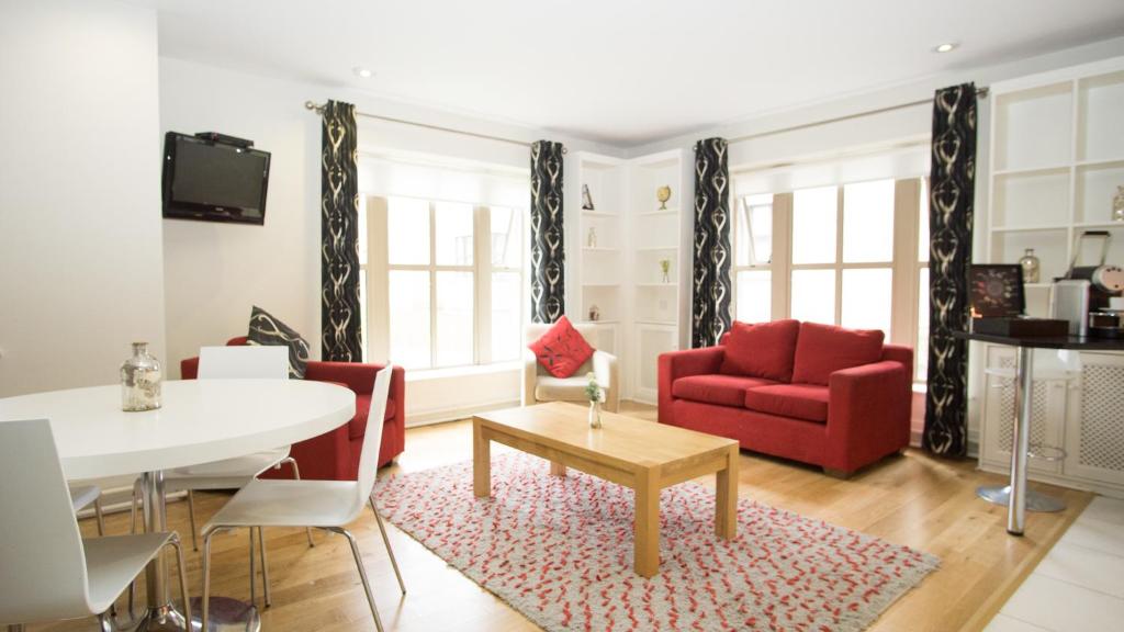 利默里克Brennan Court Guest Accommodation的客厅配有红色的沙发和桌子