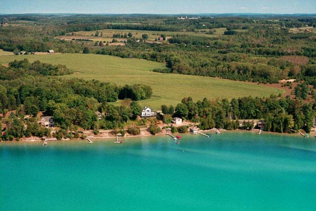 Central LakeThe Torch Lake Bed and Breakfast的鸟飞过湖泊的空中景色