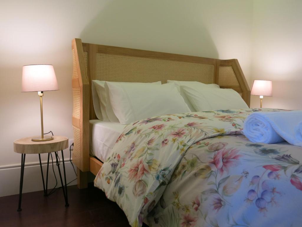 波尔图Chateau Flores的一间卧室配有一张带花卉床罩和两盏灯的床。
