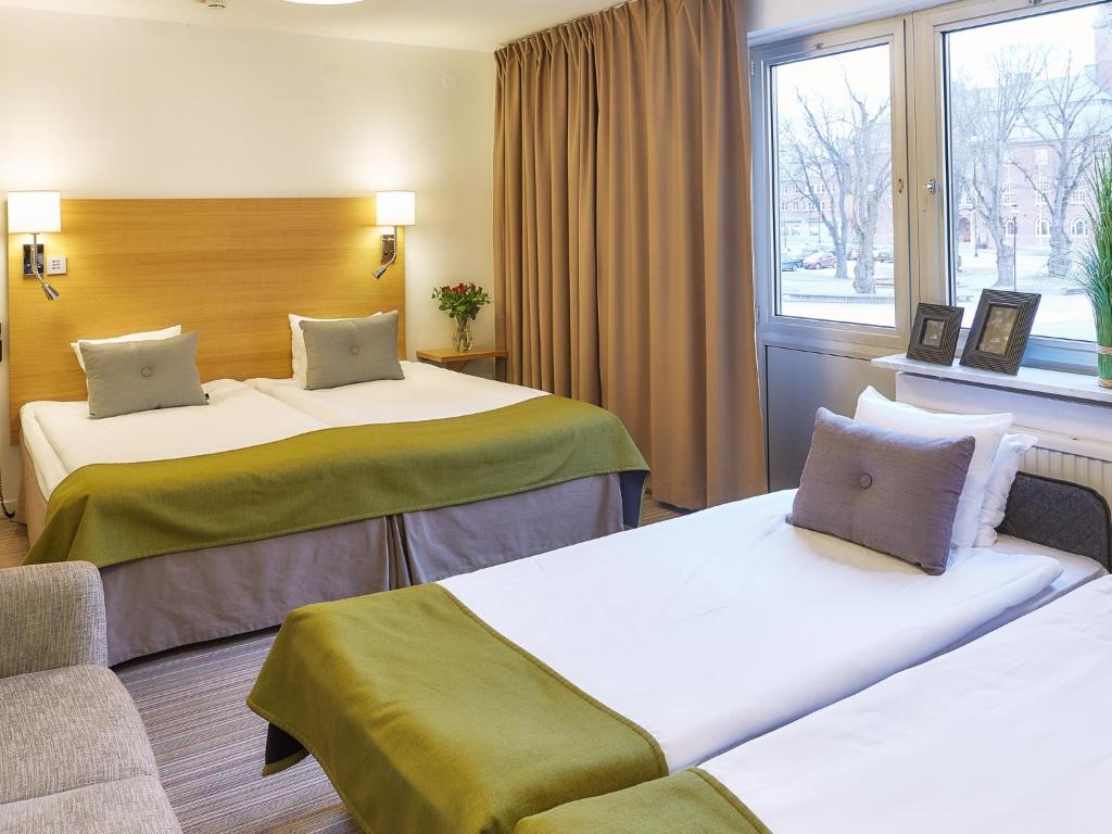 奈舍何格兰酒店的酒店客房设有两张床和窗户。
