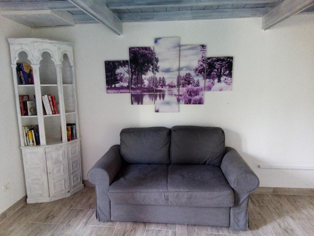 坎普码头Appartamento Scirocco的客厅配有沙发和墙上的绘画