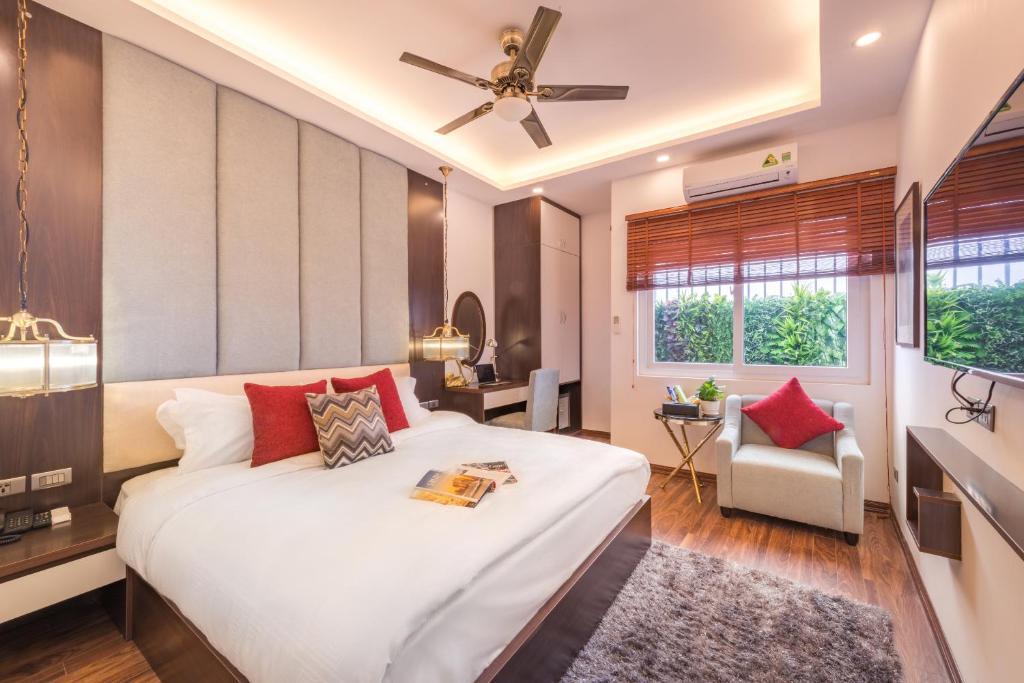 河内辉煌酒店及Spa中心的卧室配有带红色枕头的大型白色床