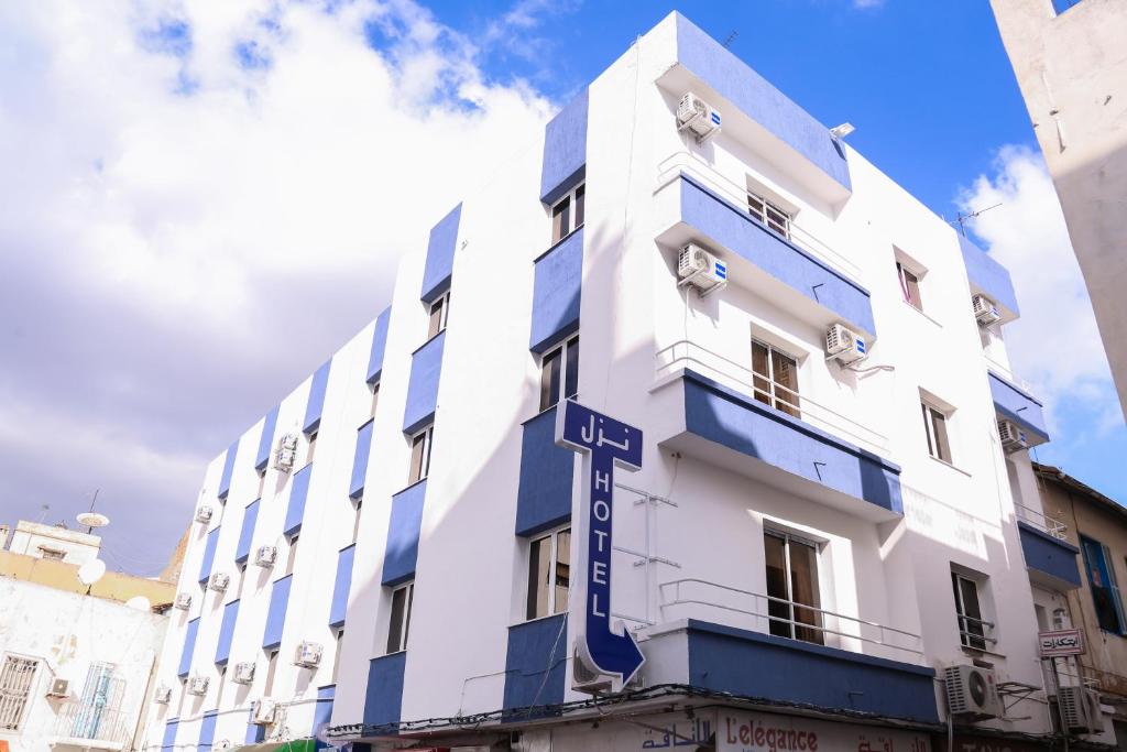 突尼斯梅彻珀勒酒店的白色的建筑,上面有蓝色的标志