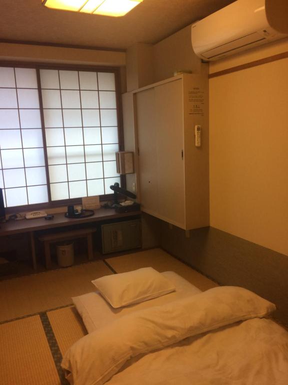 名古屋名龍的客房设有一张床、一张书桌和窗户。