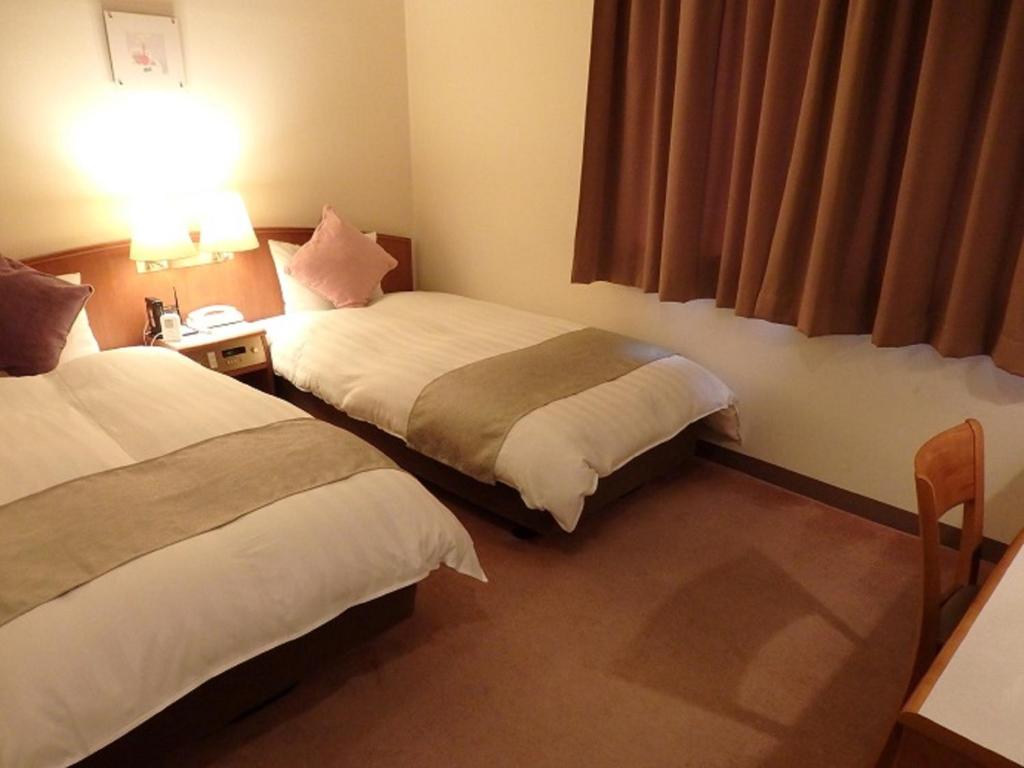IshiokaHotel Hashimotorou的酒店客房设有两张床和窗户。