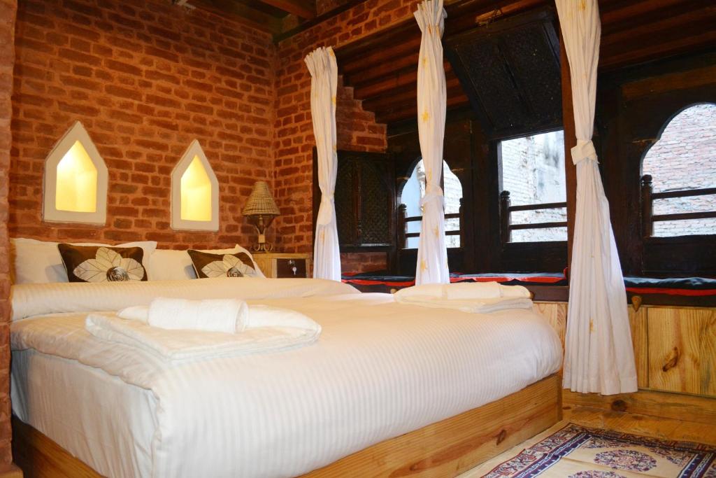 帕坦扬巴传统住宿加早餐旅馆的一间卧室设有两张床和两个窗户。