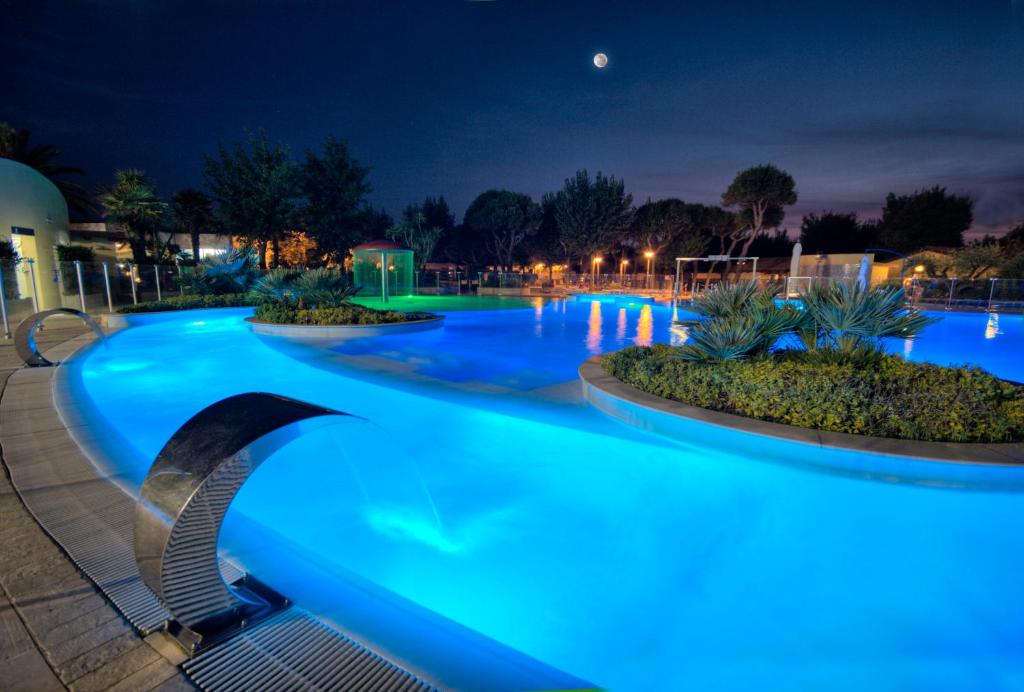努马纳Numanablu Island - Family & Sport Resort 4 stelle的夜间灯光蓝色的游泳池