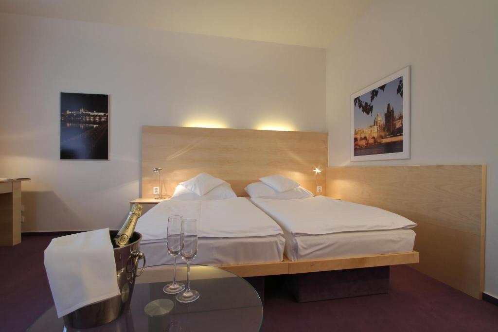 布拉格沓酒店的酒店客房配有一张床铺和一张桌子。