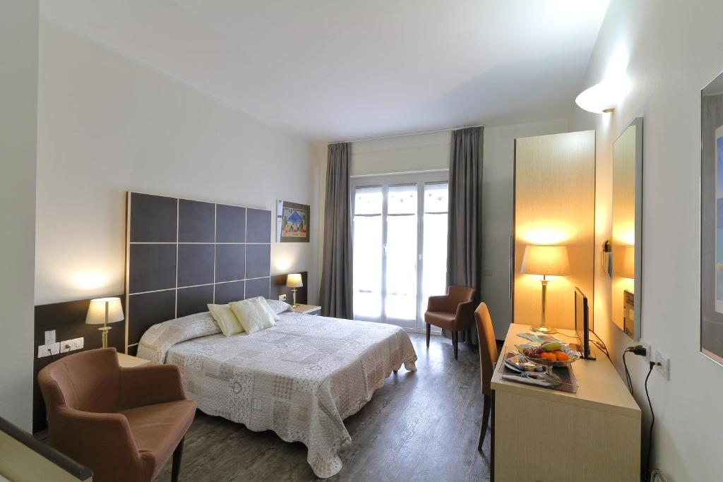 基亚瓦里法拉利酒店的卧室配有一张床和一张桌子及椅子