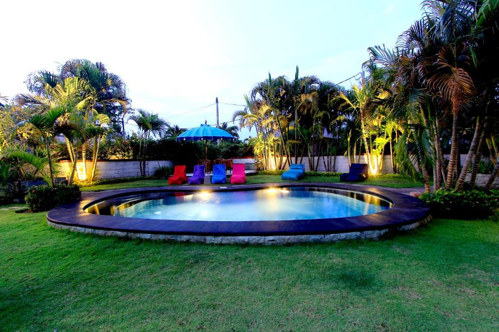 乌鲁瓦图Alamanda Bingin的庭院内的游泳池配有椅子和遮阳伞