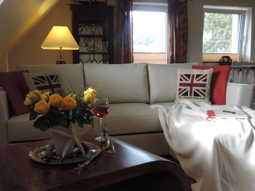 普雷罗Maisonette zum Weststrand的客厅配有白色的沙发和带鲜花的桌子