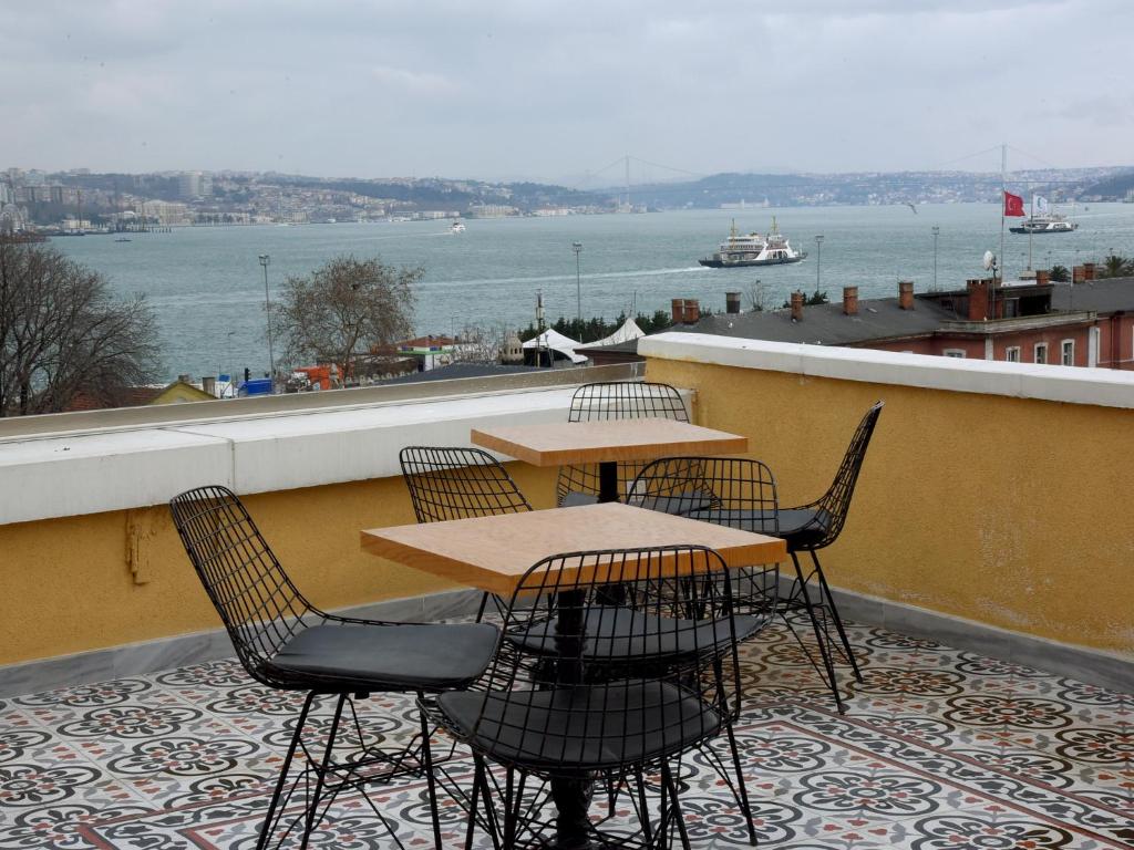 伊斯坦布尔伊思塔永酒店 的阳台配有桌椅,享有水景