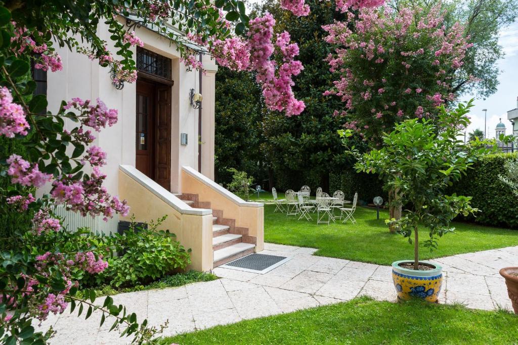 维罗纳美纳德别墅公寓的院子里有粉红色花的房子