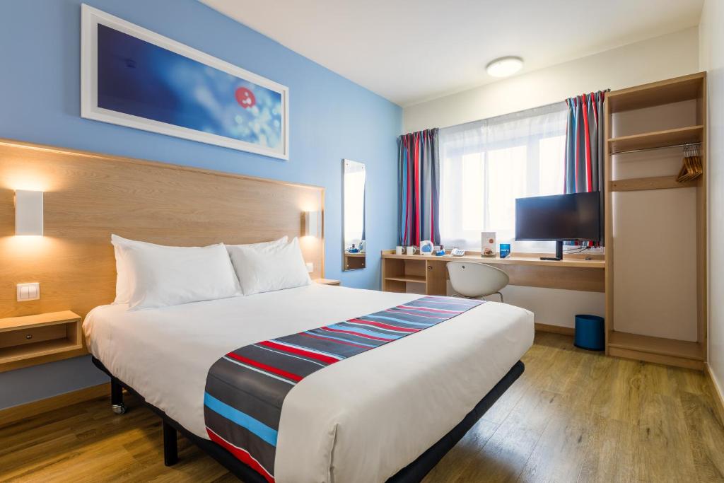 略夫雷加特河畔奥斯皮塔莱特巴塞罗那菲拉旅程住宿酒店的酒店客房设有一张大床和一张书桌。