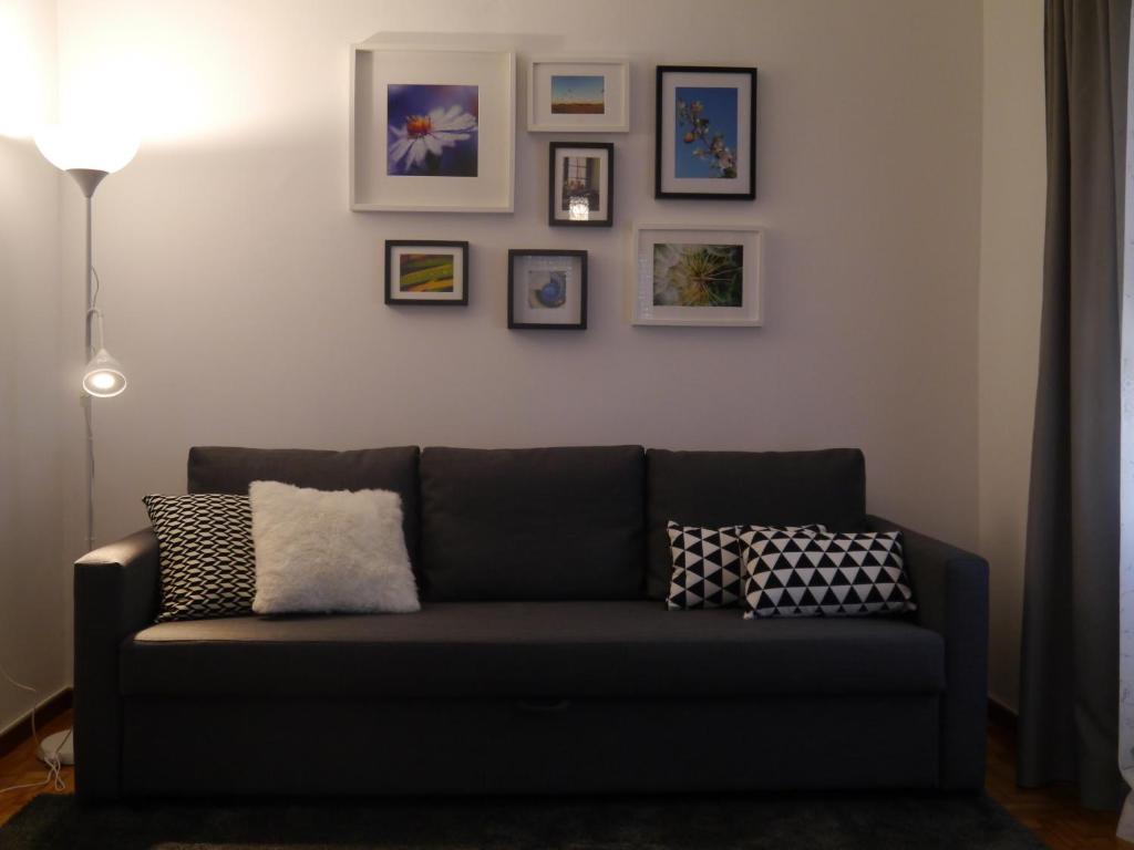 加亚新城Apartamento Boavista的客厅的沙发,墙上挂着照片