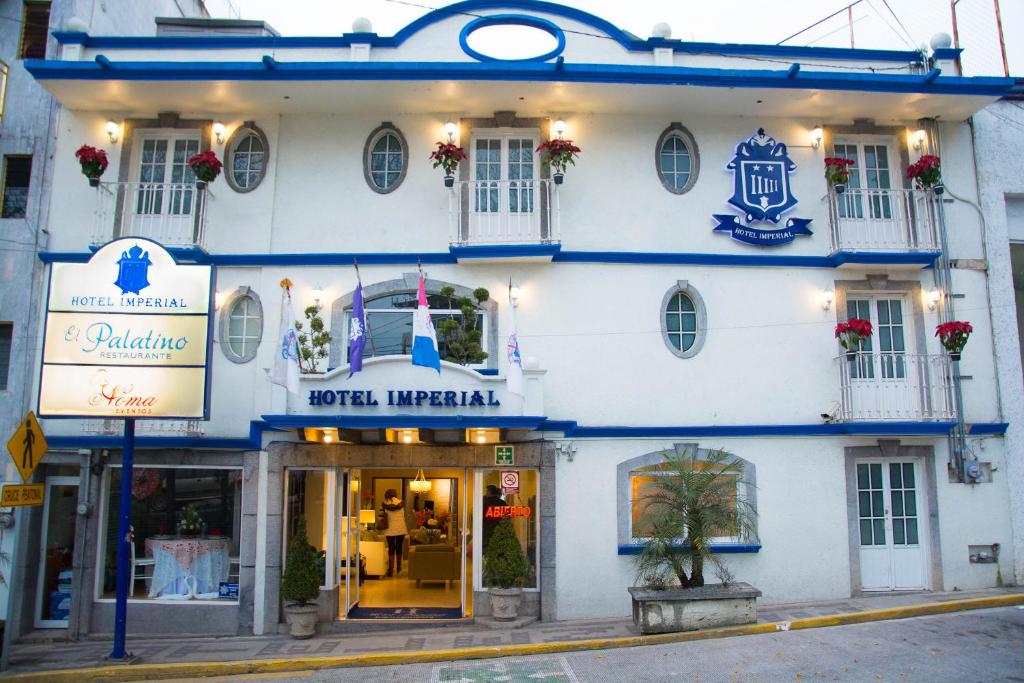 贾拉普帝国酒店的白色的建筑,在街上有蓝色的饰物