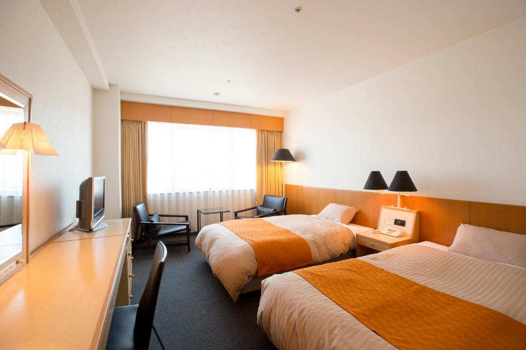 鱼津格朗米蕾奇酒店的酒店客房设有两张床和电视。