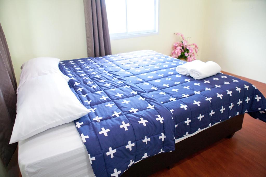 梭桃邑Bannrommai Sattahip的床上有蓝色和白色的毯子