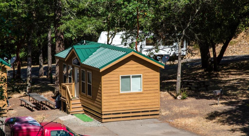 克罗弗戴尔Russian River Camping Resort Cottage 7的庭院中带绿色屋顶的小房子