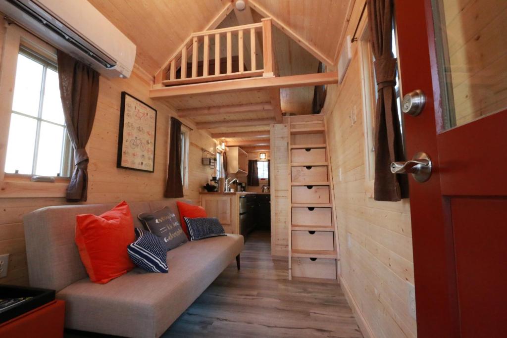 卡顿伍德Verde Valley Tiny House 17的一间客厅,客厅配有沙发,位于一个小房子里