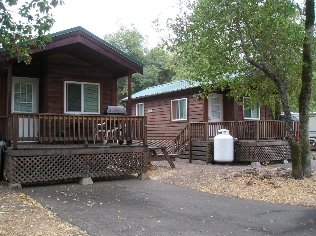 克罗弗戴尔俄罗斯河露营一室公寓小屋1号假日公园的小木屋前设有门廊和长凳