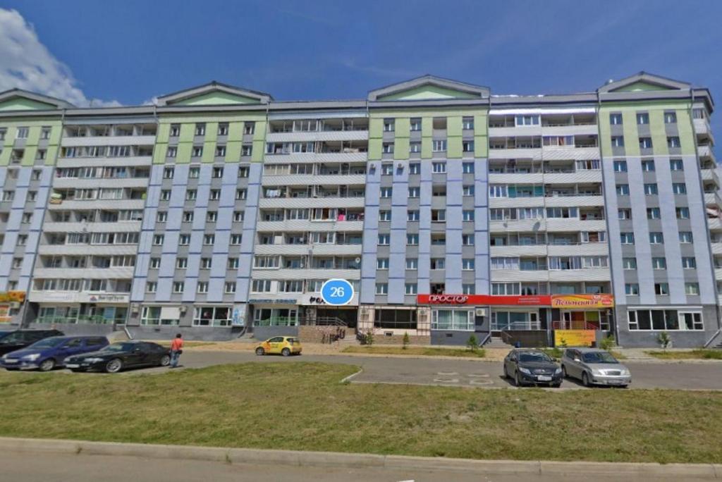 安加尔斯克Apartments 29 micro-district的停车场内停放汽车的大型建筑