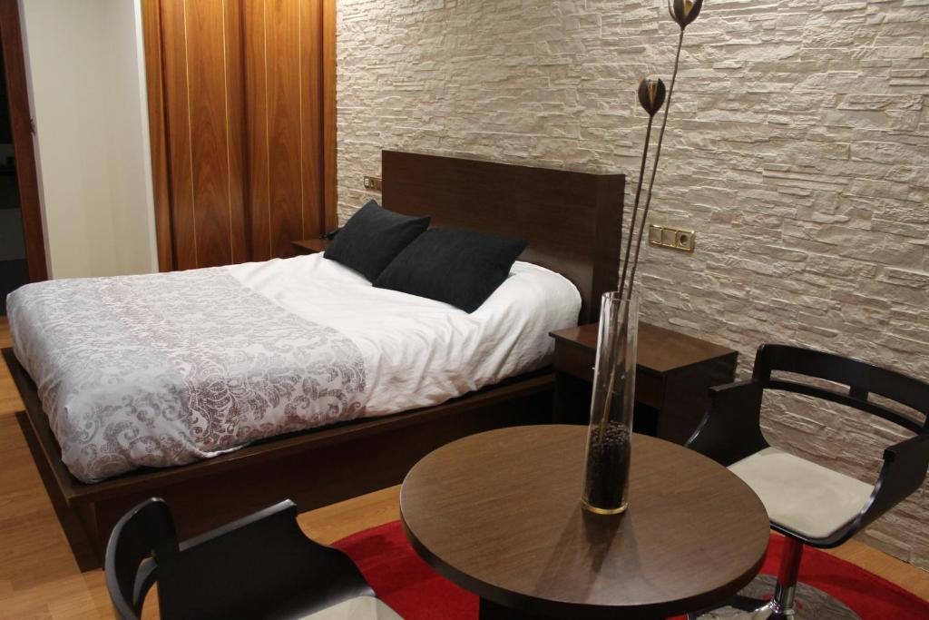 蓬费拉达埃尔卡斯特洛酒店的卧室配有一张床和一张桌子及椅子