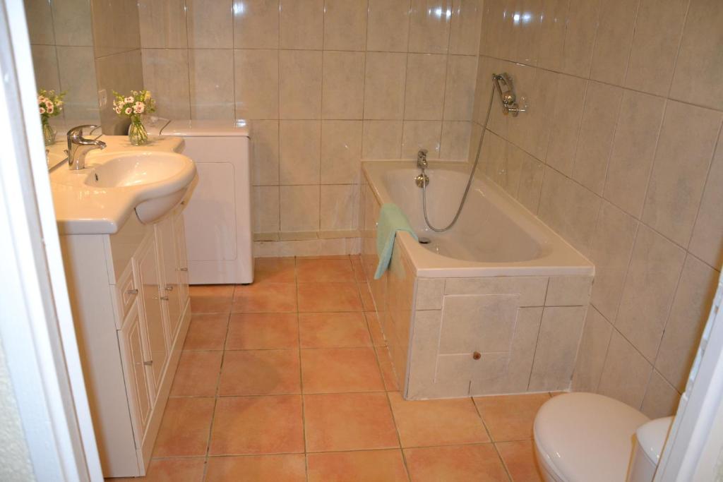屈屈尼昂赫文公寓的带浴缸、盥洗盆和卫生间的浴室