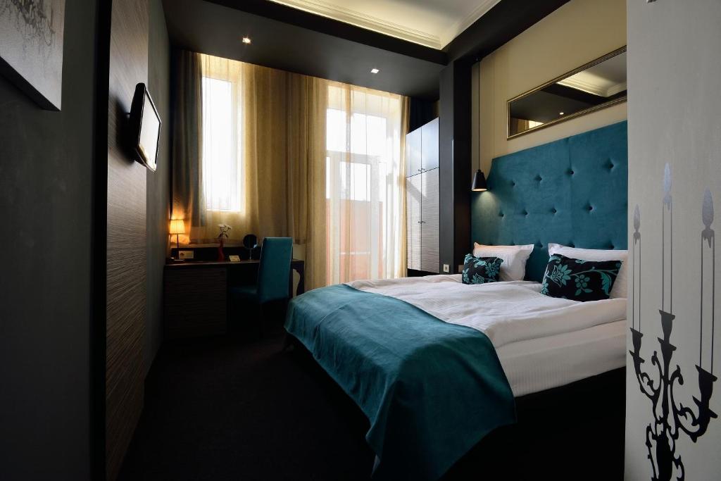 鲁塞城市艺术精品酒店的一间卧室配有一张大床和蓝色床头板