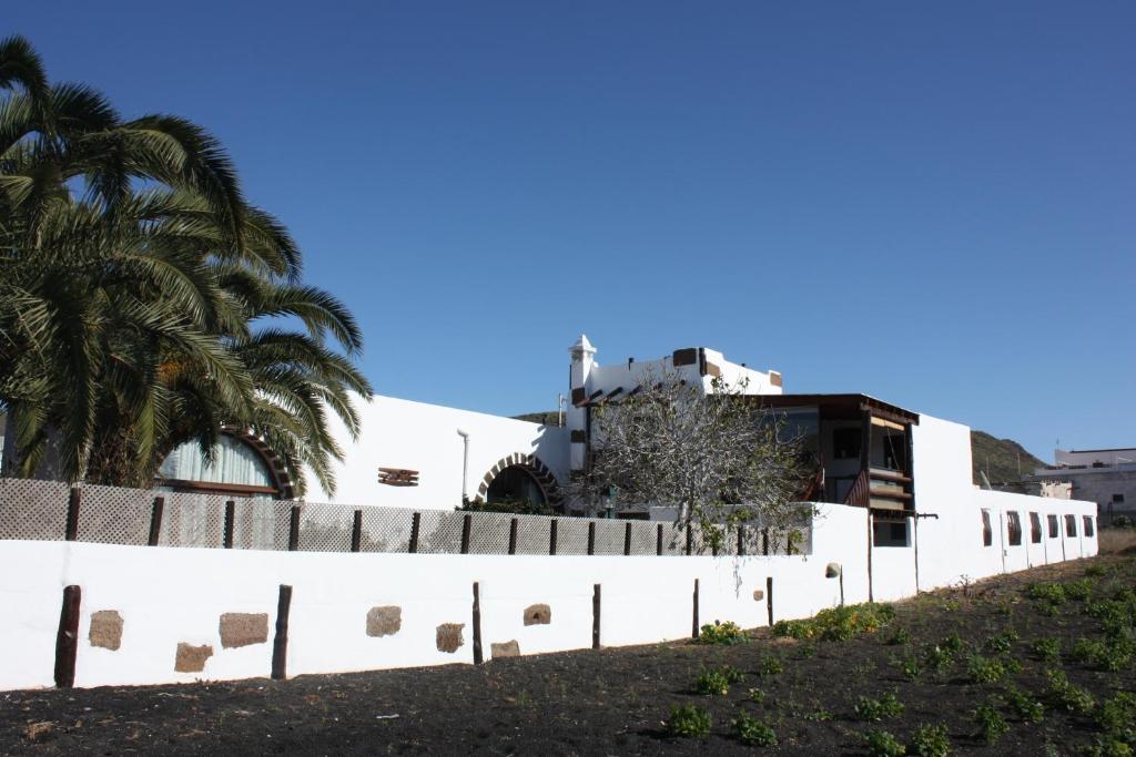 MáguezCasa Rural "La Molina"的白色的围栏,后面有一座建筑