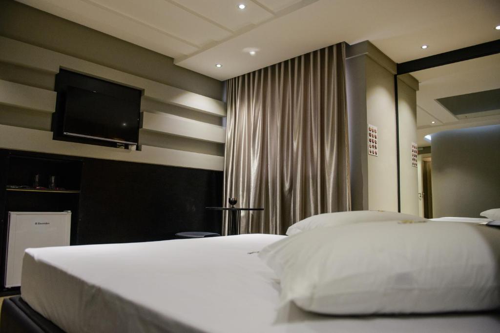 拉热斯Le Parc Motel的一间卧室配有两张床和一台平面电视