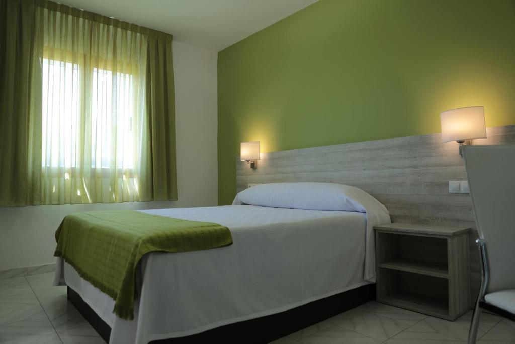 Reinante普拉亚卡特德雷里斯广场酒店的卧室设有一张白色大床和一扇窗户。