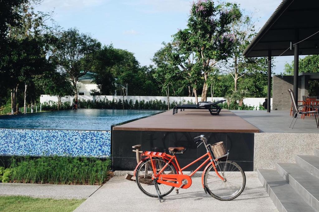 尖竹汶利维尔拉旺酒店的一辆红色自行车停在游泳池旁